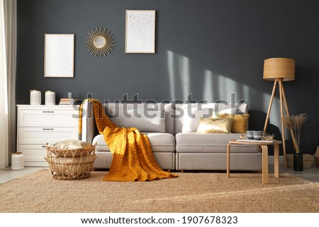 Stylish sofa with soft plaid in room. Idea for interior design Royalty-Free Stock Photo #1907678323