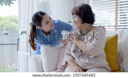 Young asian woman or nurse home care hand on senior grandmother shoulder give support empathy to elderly lady or older people in assisted living homecare mental health sick relief concept. Royalty-Free Stock Photo #1907685682