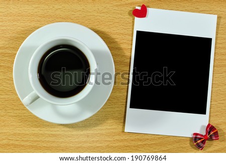 Blank instant photo and coffee on wooden table