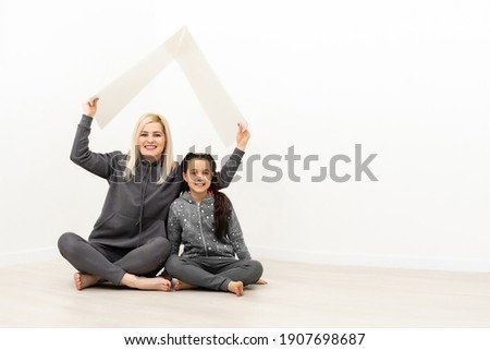 concept housing a young family. Mother father and child in new house with a roof at empty brick wall