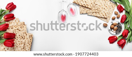 Flat lay composition with matzos on white background, space for text. Passover (Pesach) celebration Royalty-Free Stock Photo #1907724403