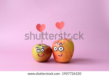 Loving cartoon couple of apples with hearts on a pink background. Valentine's card. Fun food.
