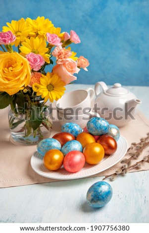 Easter table setting with easter eggs and spring flowers. Happy Easter. Congratulatory easter background.