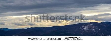 The Sun behind the clouds in winter in the Carpathian mountains