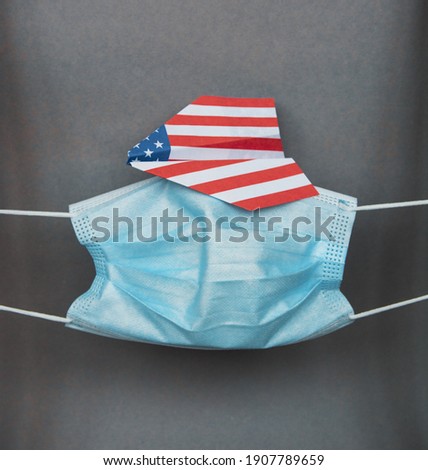 medical face mask paper plane in american  flag - concept traveling USA abroad during coronavirus pandemic, new flight ban rules travel, aviation business