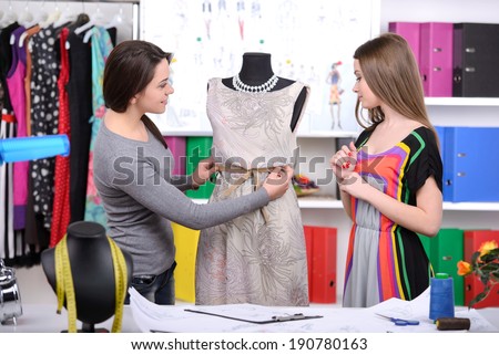Fashion designers at work. Two cheerful young women working at fashion design studio