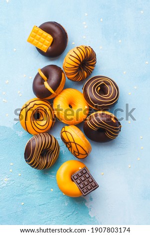 Tasty Glazed Donuts.  Mini  donuts with chocolate on rustic blue background. Top view, blank space