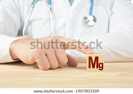 essential element and minerals for humans. doctor recommends taking magnesium. doctor talks about the benefits of magnesium. magnesium- Health Concept. Mg alphabet on wood cube. Royalty-Free Stock Photo #1907803309