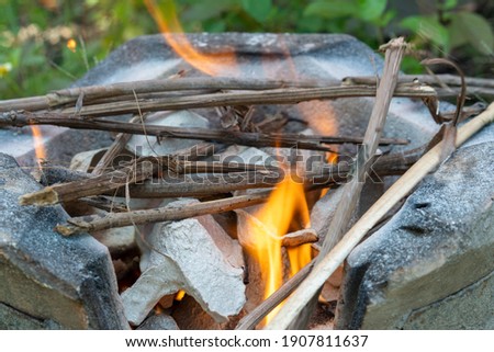 Burning black charcoal in the old stove with paper and dry wood. It produces a lot of smoke when it burns.