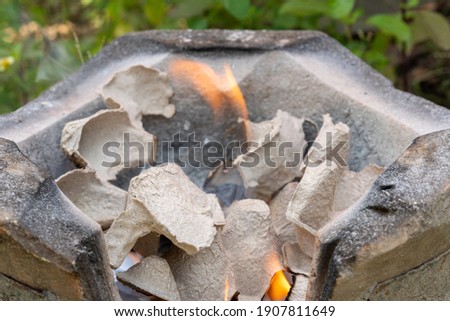 Burning black charcoal in the old stove with paper and dry wood. It produces a lot of smoke when it burns.