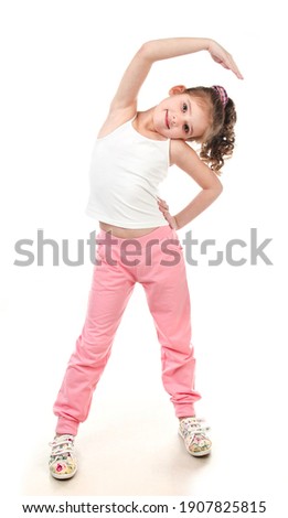 Cute little girl doing gymnastic exercise isolated on a white