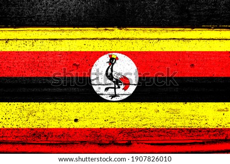 National flag of Uganda, abbreviated with ug; a realistic 3d image of the national symbol from an independent country painted on a wooden wall