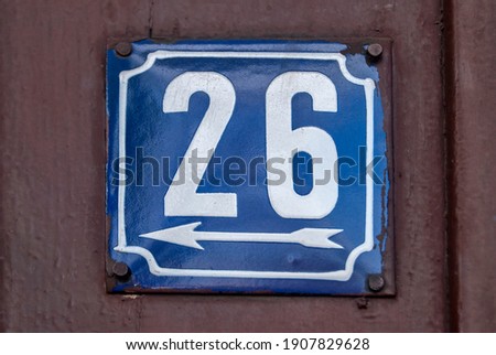 Weathered grunge square metal enameled plate of number of street address with number 26