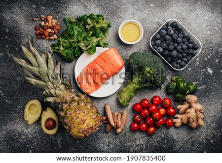 Anti inflammatory diet concept. Set of foods that help to reduce inflammation - plant based ingredients, fresh fruit, green vegetables. Healthy diet products, top view, stone background. Toned Royalty-Free Stock Photo #1907835400