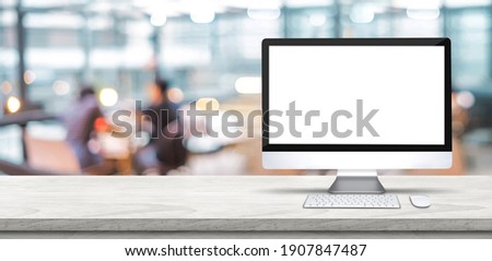 Blank screen desktop computer on wooden table top with blur people working at creative office bokeh background,Mock up for display or montage of design Royalty-Free Stock Photo #1907847487
