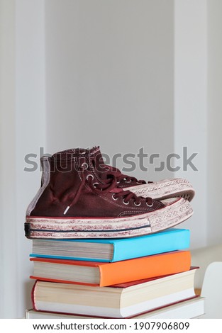 Old canvas shoes on books stack