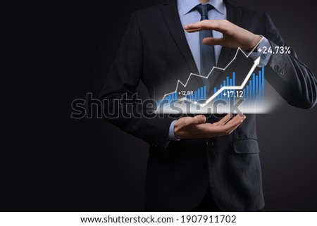 Businessman on a black background presses, presses a finger on a positive growth arrow. Graphs of indicators. Business development and finance concept.