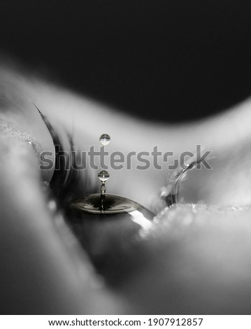 surreal black and white photo of a waterdrop in an eye, photoshop montage