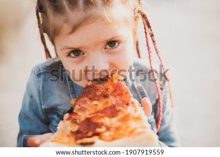 Child eating pizza. Fastfood for kids. Junkfood addiction. Italian cuisine. Children food. Childhood obesity. Tasty food for kid Royalty-Free Stock Photo #1907919559