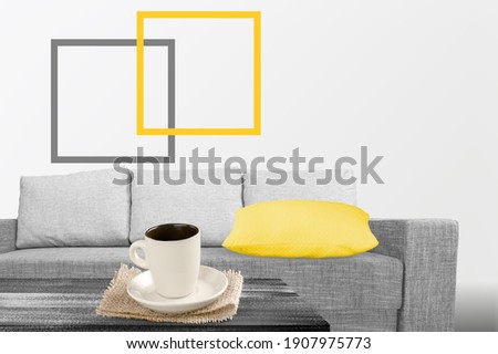 Illuminating yellow and ultimate Gray - trendy colors of year 2021. Gray sofa with yellow pillow