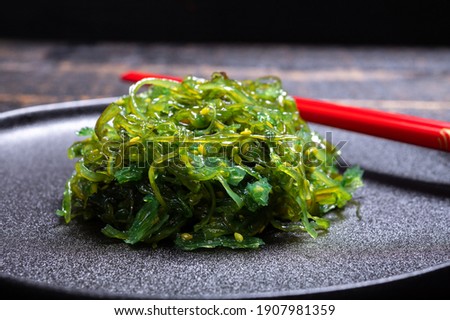 Tasty vegetarian sea food from Japan, green seaweed wakame salad close up