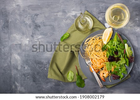 pasta with shrimp and wine on gray background from above