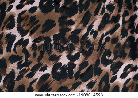 Fabric with a print of the skin of a cheetah, leopard, wild predators. A woman in clothes made of such fabric feels strong, bold and a little wild. Top view
