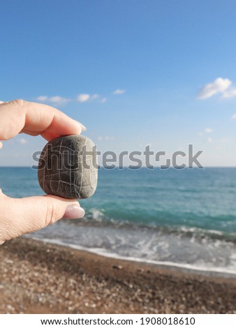 A hand holding a bizarre stone. Concept for the summer vacation.