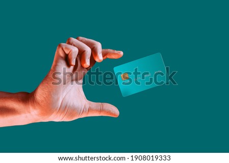 Close up male hand and levitating template mockup bank credit card with online service isolated on green background Royalty-Free Stock Photo #1908019333