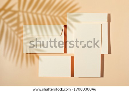 Mockup of blank cards and envelopes over neutral beige background. Invitation, branding, thank you card template. Top view, flat lay