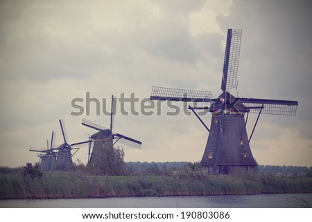 It is a lot of windmills in Kinderdijk, processing under an old card