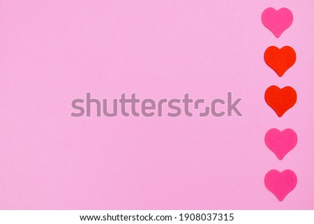 One other heart in the crowd among others. An outstanding heart on a pastel background with many other heart colors. Minimal concept. View from above. Flat lay. High quality photo