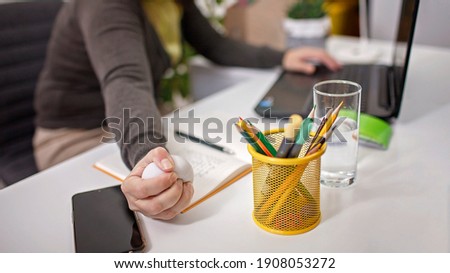 Woman squashing anti stress white ball in her hand to reduce stress during online conference in lockdown, mental care and health, new normal reality, social distant job, indoor lifestyle Royalty-Free Stock Photo #1908053272
