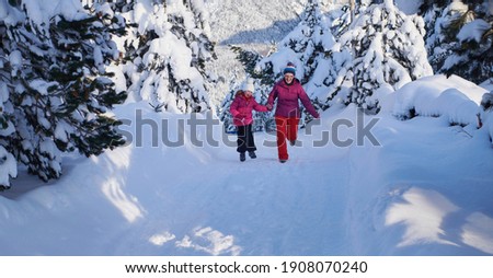 mother and daughter walking at beautiful sunny winter day