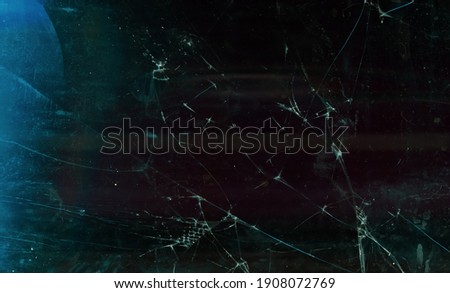Shattered background. Defocused broken glass. Blur dark frozen distressed dirty tablet display with dust scratches fingerprints stains blue lens flare.