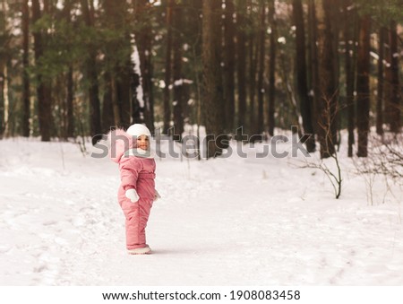 A little pretty girl stands in the winter forest. Winter Walk