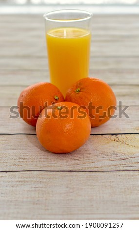 Fresh squeezed orange juice with whole fresh oranges. Concept oranges and glass of juice close-up photo