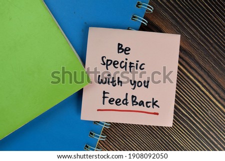 Be Specific With You Feedback write on sticky notes isolated on Wooden Table.