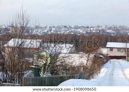 view of a suburban village in Russia with small wooden houses, winter, houses in the snow.