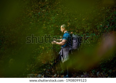 Professional photographer taking picture of a mountain valley
