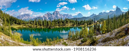 Autumn scenery with lake reflection in the Dolomites mountains at Lake Federa