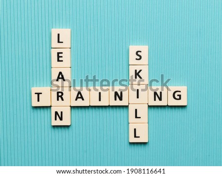 LEARN TRAINING SKILL crossword made from square letter tiles on turquoise background.Business concept.