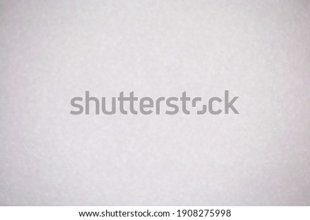 Monochrome light gray surface with background blur and vignetting. Background, pattern, texture.