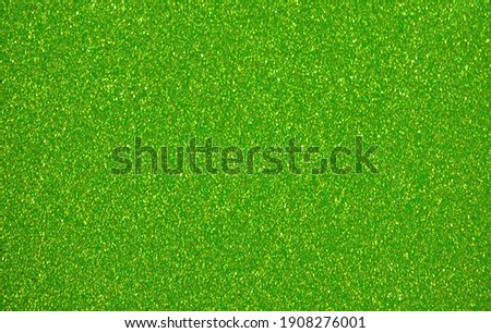 Monochrome green surface with small splashes of golden color with blurred background. Background, pattern, texture.