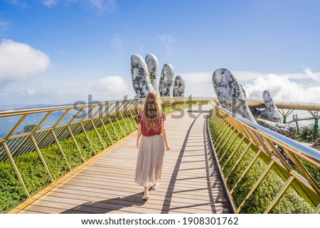 Young woman tourist at Famous tourist attraction - Golden bridge at the top of the Ba Na Hills, Vietnam Royalty-Free Stock Photo #1908301762
