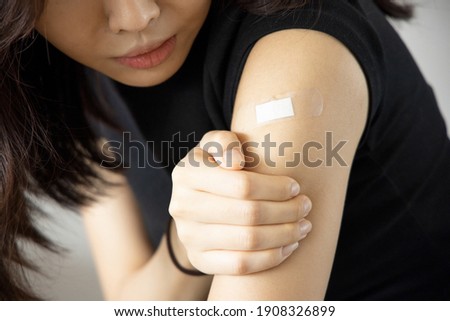 Asian woman receiving getting vaccinated immunity with bandage on her upper arm, concept of innoculation, vaccination, side effects of vaccine Royalty-Free Stock Photo #1908326899