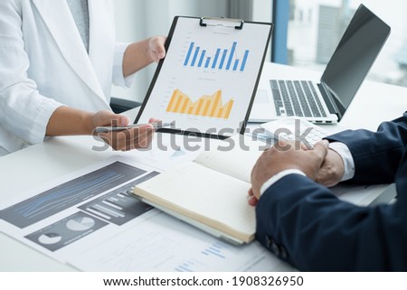 Two business leaders talk about charts, financial graphs showing results are analyzing and calculating planning strategies, business success building processes.