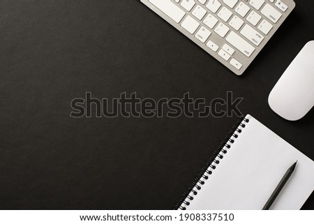 Above overhead flatlay view photo image of computer keyboard wireless mouse spiral notebook diary organizer pencil isolated black color backdrop with space for design