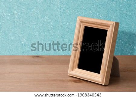 wooden photo frame on table, blue wall