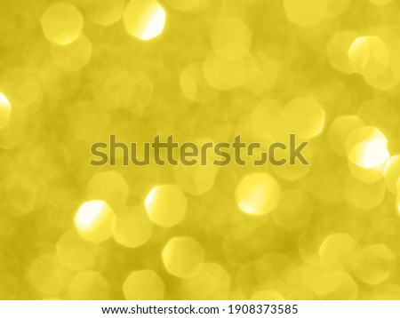 Illuminating yellow - trendy color of the year 2021. Sparkling background with bokeh made of Illuminating yellow 2021 color. Color of year 2021 blurred backdrop for holidays and parties. Copy space